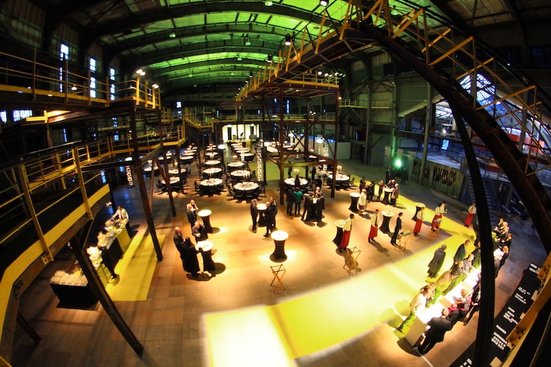 salle du lavoir équipée avec espace conférence, repas et apéritif. couleurs prédomimantes le jaune et le noir